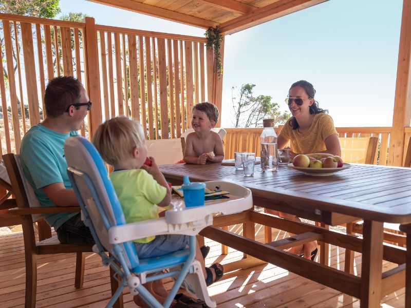 Eltern mit zwei Kindern auf der Terasse der SunLodge BigLeaf