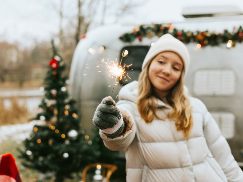 Mädchen mit Wunderkerze feriert Silvester auf dem Campingplatz